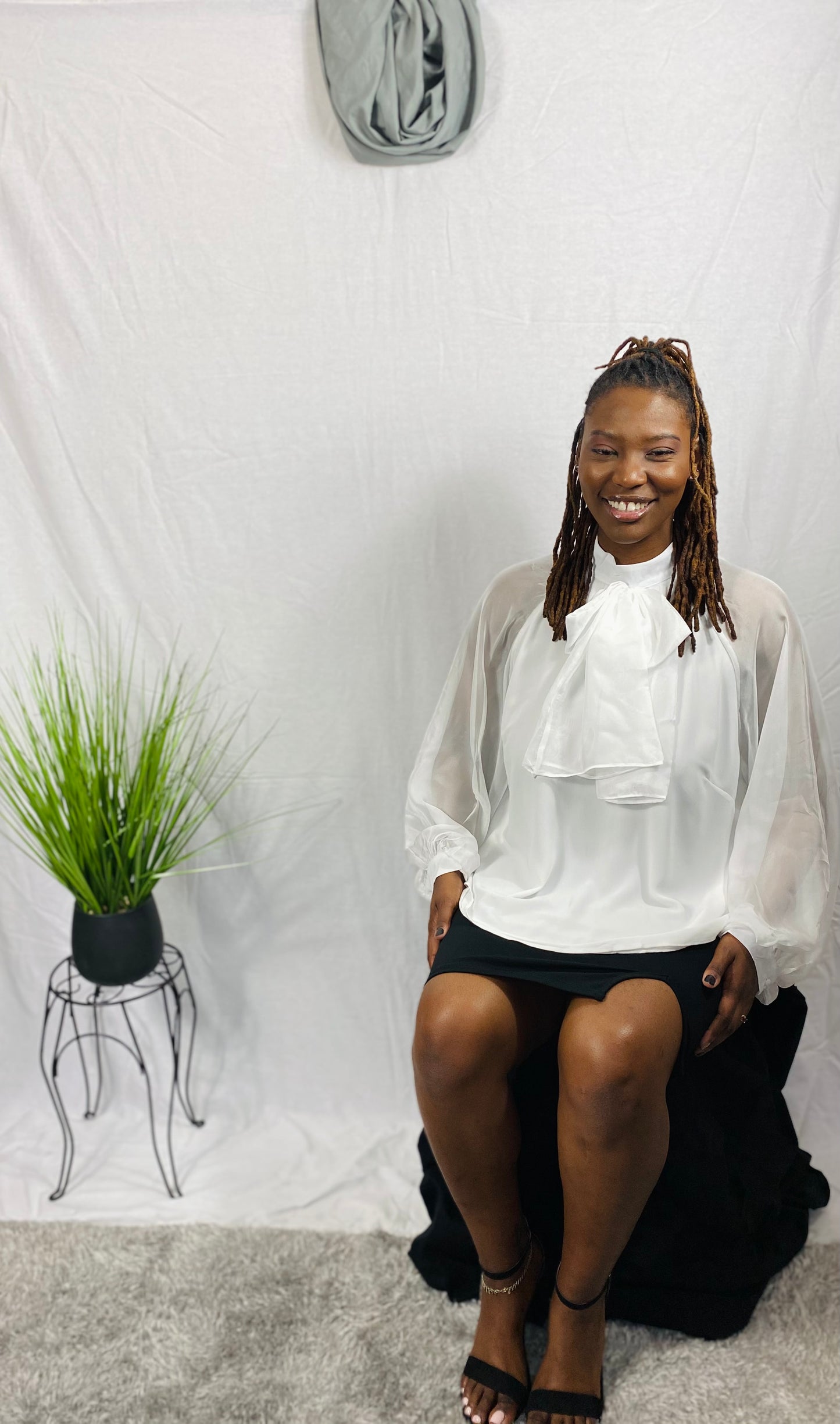 White blouse with a bow and sheer bishop sleeves.